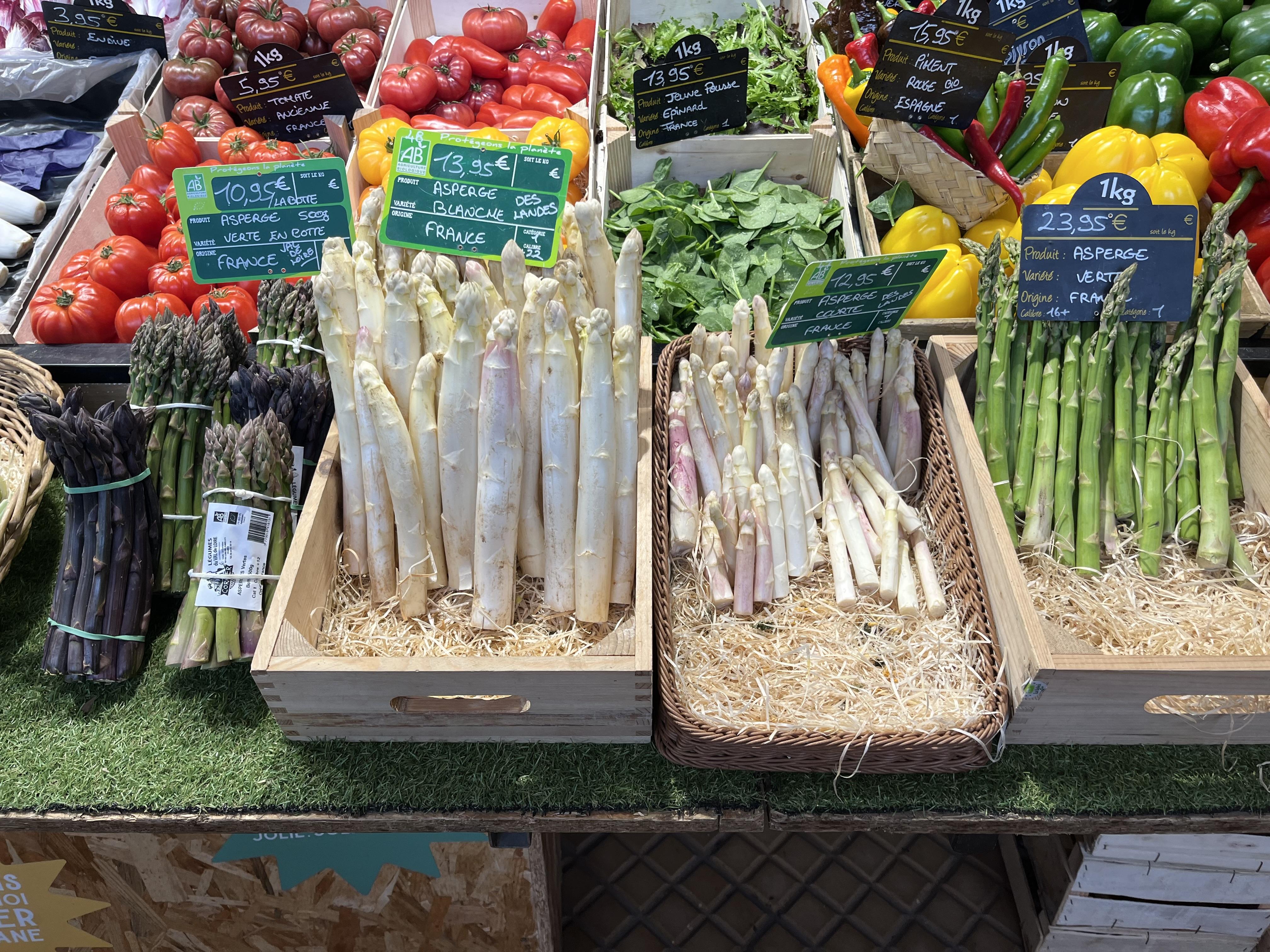 Witte, groene en paarse asperges op een markt in Frankrijk. 