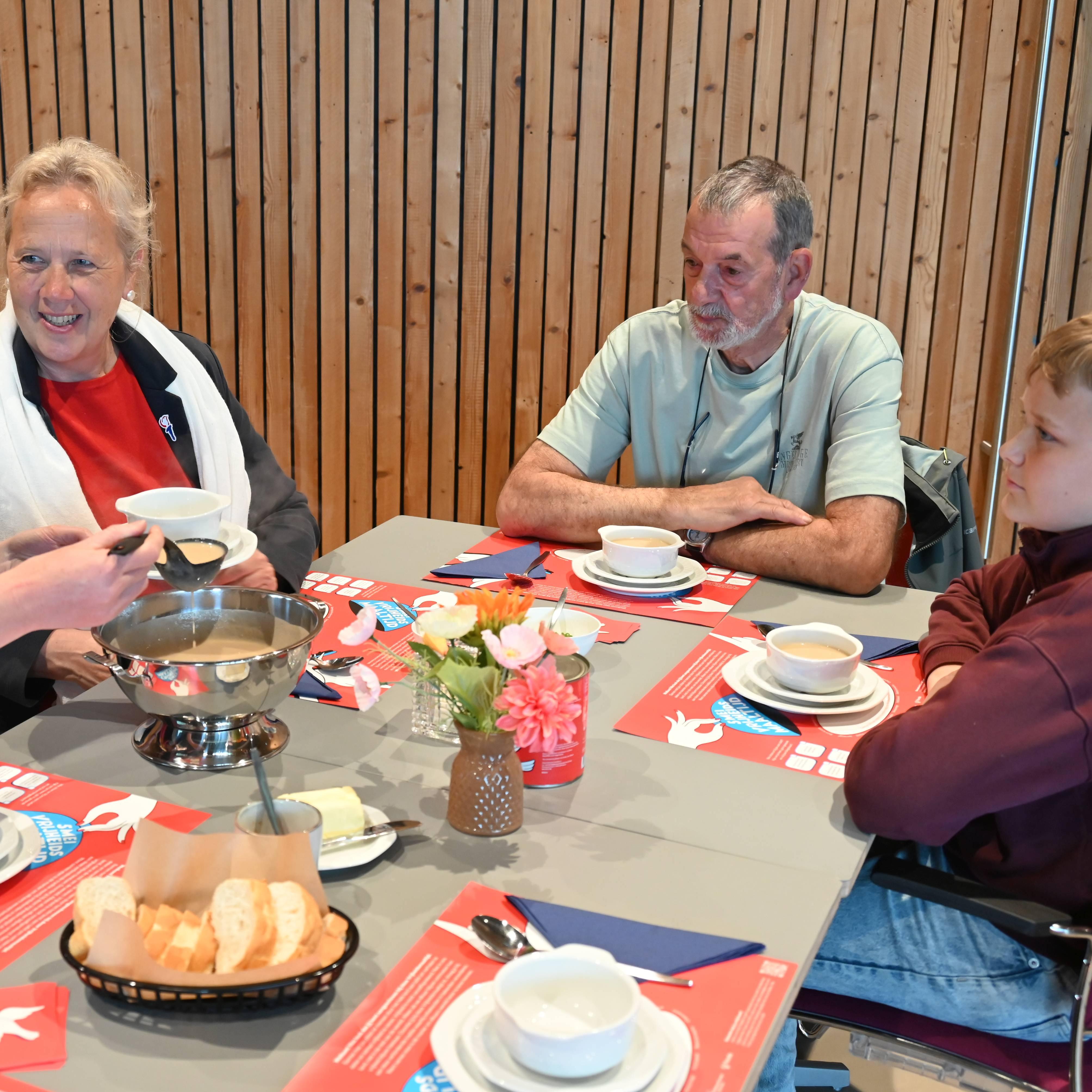 De soep wordt voor burgemeester Inge Nieuwenhuizen opgeschept door Vera Verhagen, geheel rechts kijkt de 12-jarige Stefano Zanting goedkeurend toe, net als zijn opa Jos.