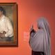 Een bezoeker aan de tentoonstelling ‘Amrita Sher-Gil. Europa is van Picasso, India is van mij’ bij het schilderij 'Jonge man met appels' (1932).