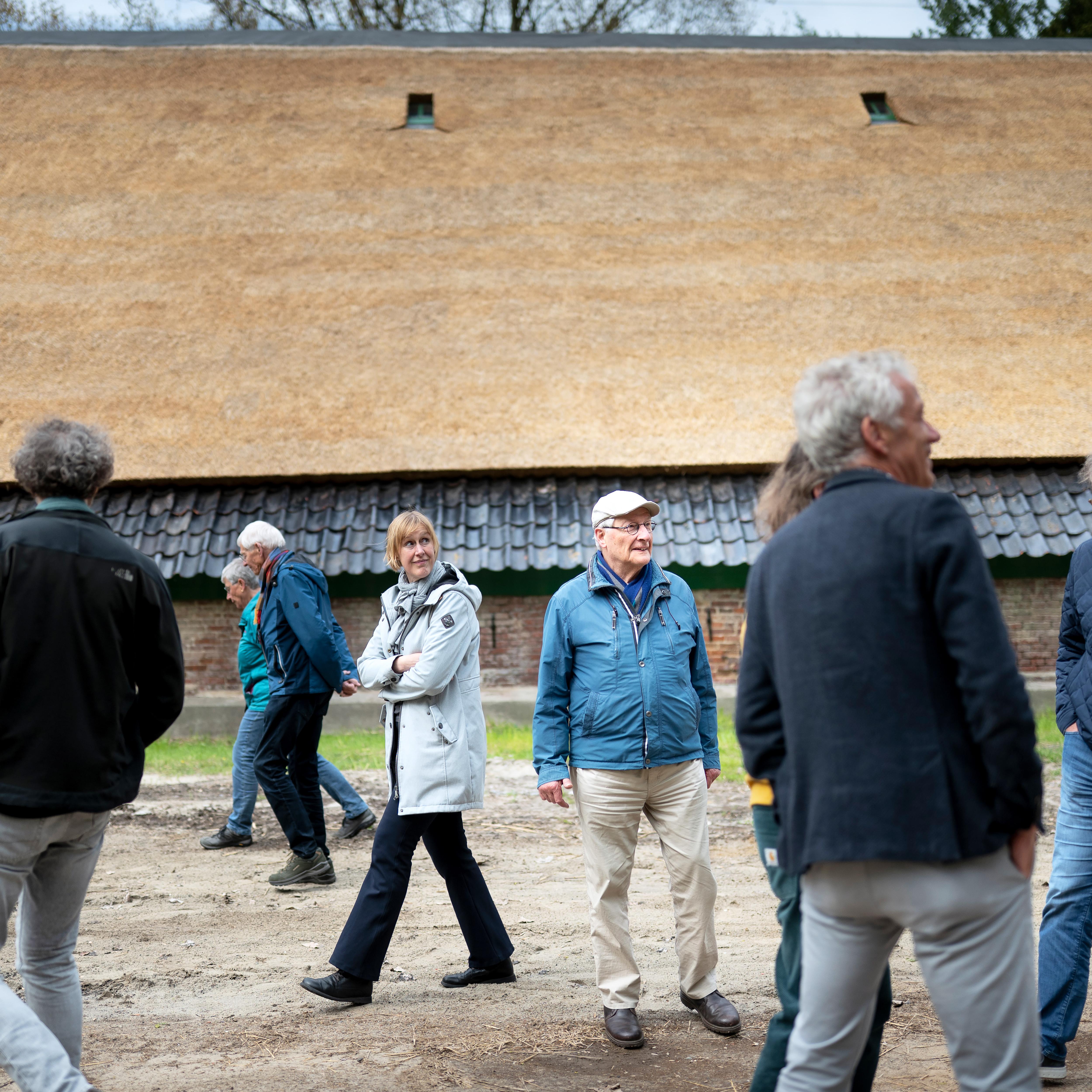 Genodigden bewonderen de gerestaureerde boerderij Euvelgunnerheem.