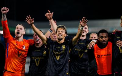 Luca Everink viert een overwinning van FC Emmen met uitsupporters.