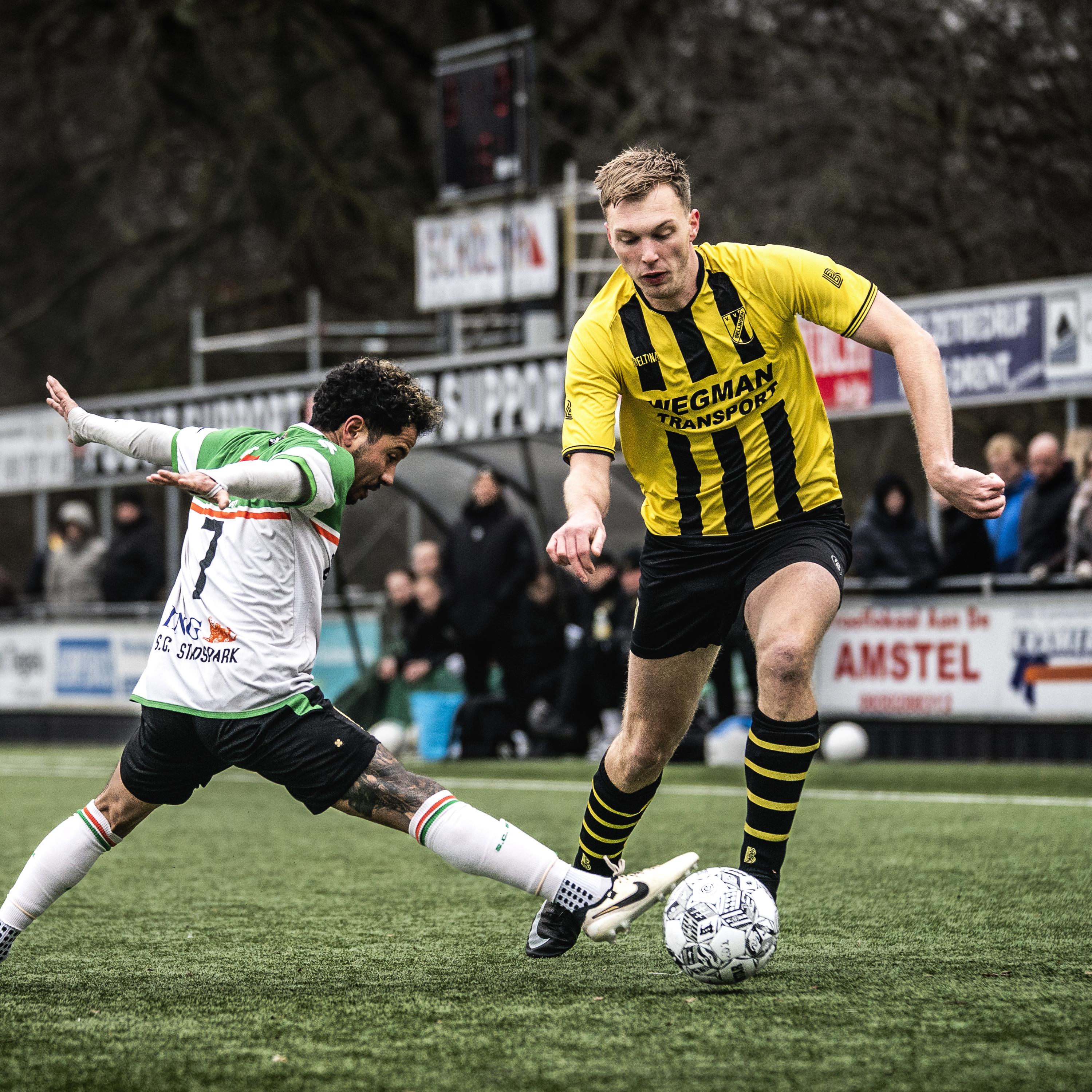 Dennis de Roo (rechts) van Sellingen passeert Païdjah Davidson Descelles van SC Stadspark. Beide clubs hielden het in de derde klasse tot de laatste wedstrijd spannend. Uiteindelijk werd SC Stadspark kampioen door een beter doelsaldo.