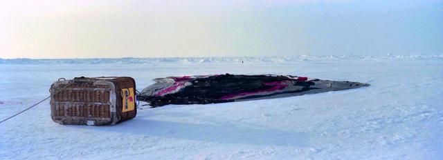 De ballon ligt op de uitgestrekte ijsvlakte.