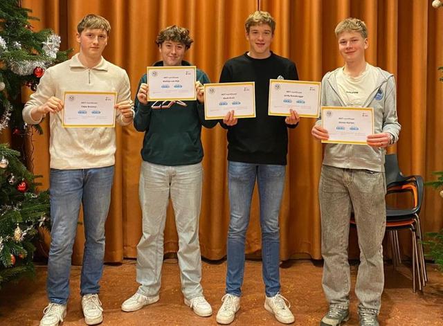 Olivier (links) en zijn vrienden met hun certificaat van de maatschappelijke diensttijd.