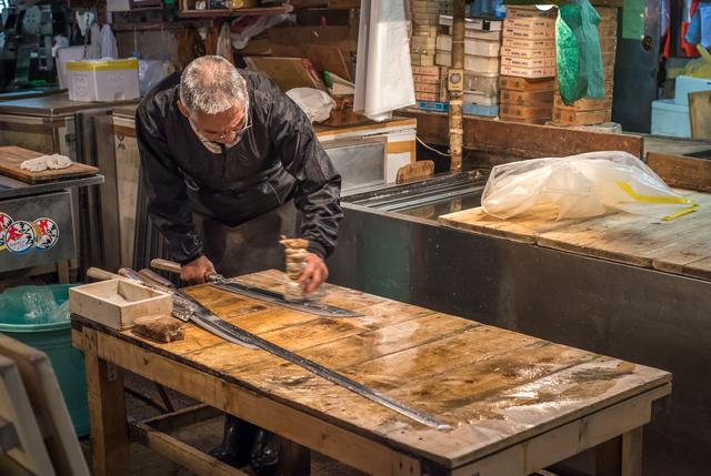 Messenslijper met traditionele messen op de grootste vismarkt in Tokio.