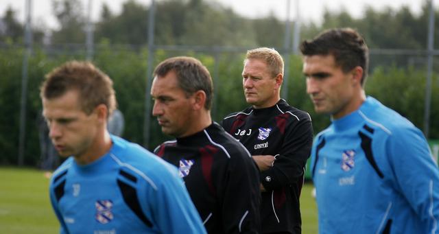 Hoofdtrainer Jan de Jonge (rechts in het zwart) en assistent trainer Gert Heerkes (links in het zwart) in het seizoen 2009-2010 in actie bij sc Heerenveen.