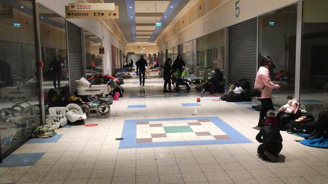 De hal in het winkelcentrum is ingenomen dor vluchtelingen.
