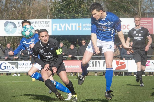 Menno Heerkes (midden, in het zwart) als aanvoerder van Hoogeveen in actie tegen Robert Veen van VKW (rechts).