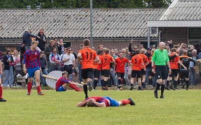 IJhorst feest, terwijl spelers van HH Combi verslagen op de grond liggen na de late 1-0.