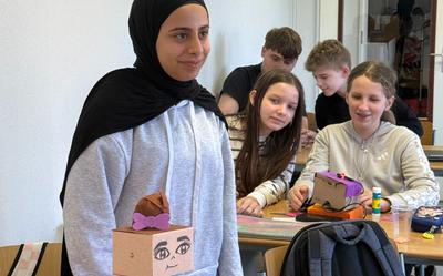 Een leerling van ISK Westermarke toont haar zelfgemaakte robot tijdens de les digitale en AI-geletterdheid.