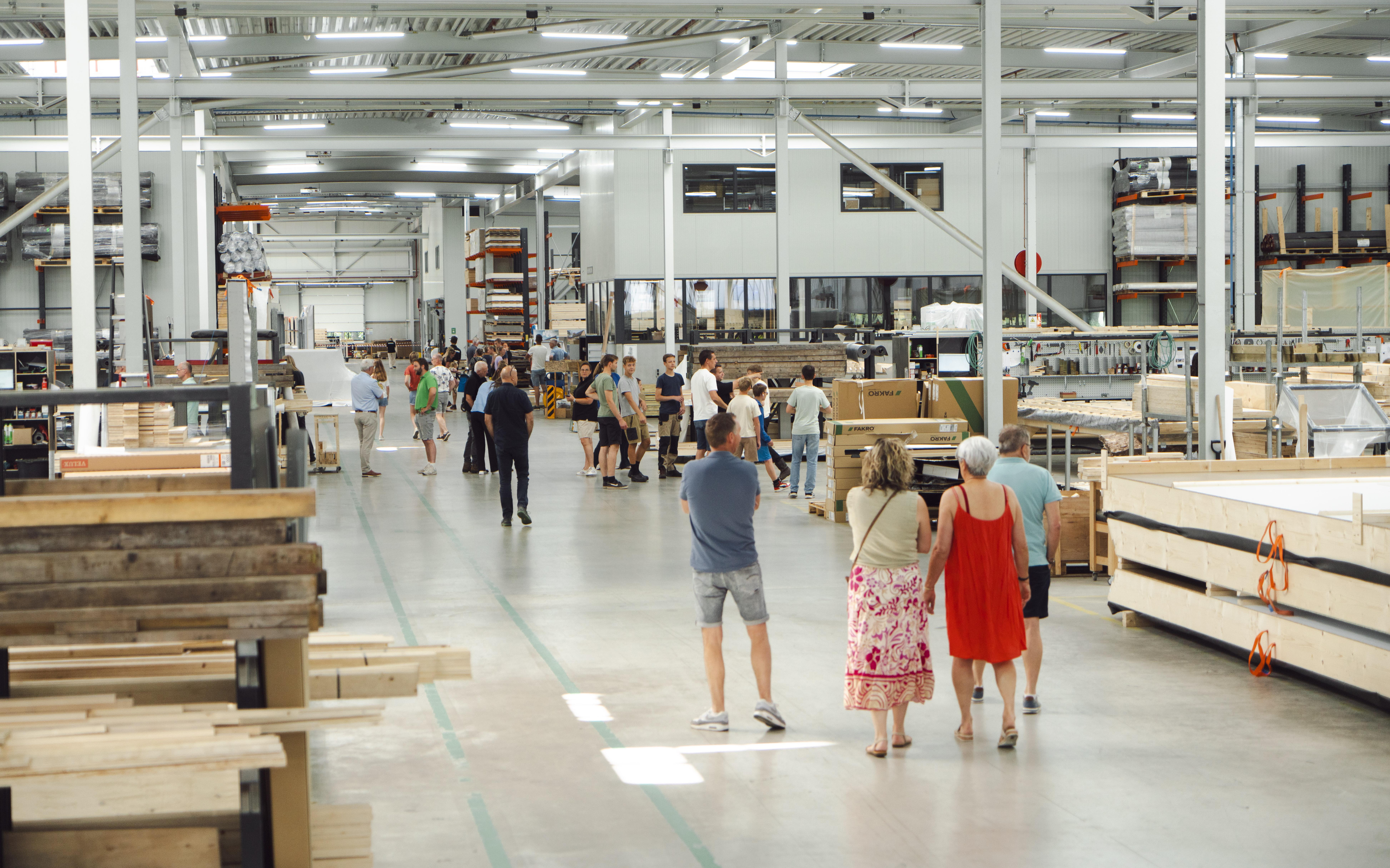 Bezoekers lopen tijdens een eerdere editie van de Dag van de Houtbouw door de prefab productiehal van Emergo in Stadskanaal.