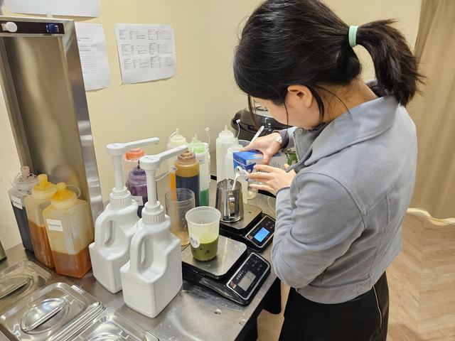 Lily terwijl ze een bubble tea maakt bij Lian Tea.